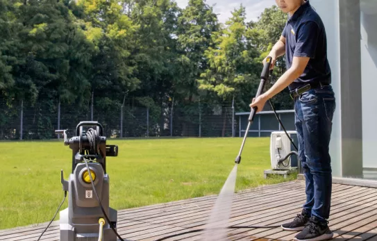 Medewerker reinigt een terras met een hogedrukreiniger