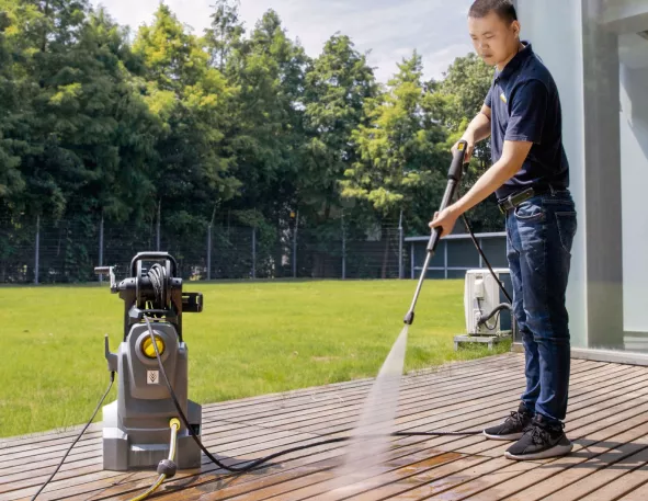 Medewerker reinigt een terras met een hogedrukreiniger