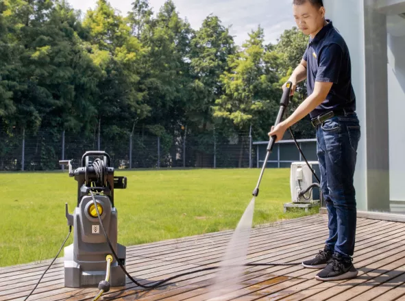 Medewerker reinigt een terras met een hogedrukreiniger