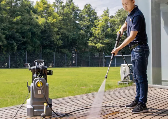 Medewerker reinigt een terras met een hogedrukreiniger